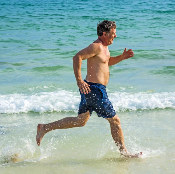 Man runs along the beautiful beach — Stock Photo, Image