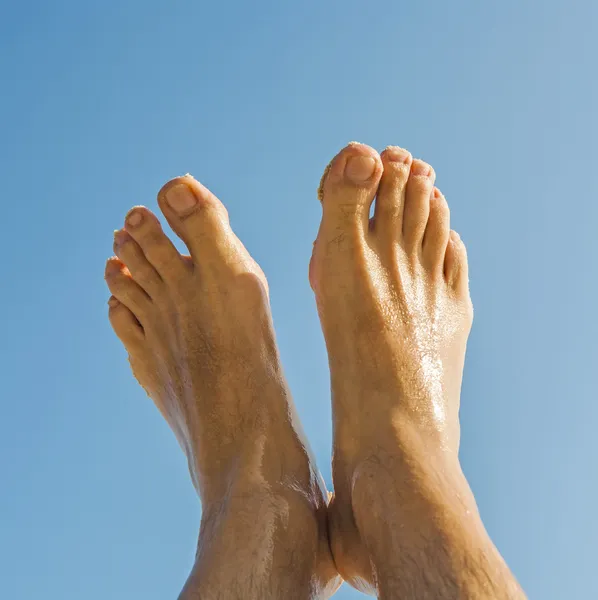 Perna e pés de um homem sob o céu azul — Fotografia de Stock