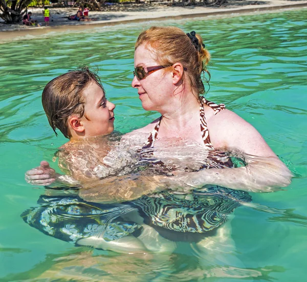 Mother and son hugging in the ocean — Stock Photo, Image