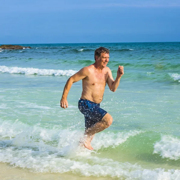 Man runs along the beautiful beach — Stock Photo, Image