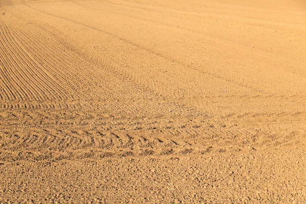 Freshly plowed field with marks of tire — Stock Photo, Image