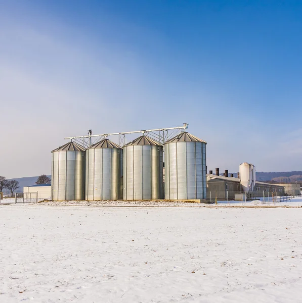 Landschap met silo en sneeuw wit hectare met blauwe hemel — Stockfoto