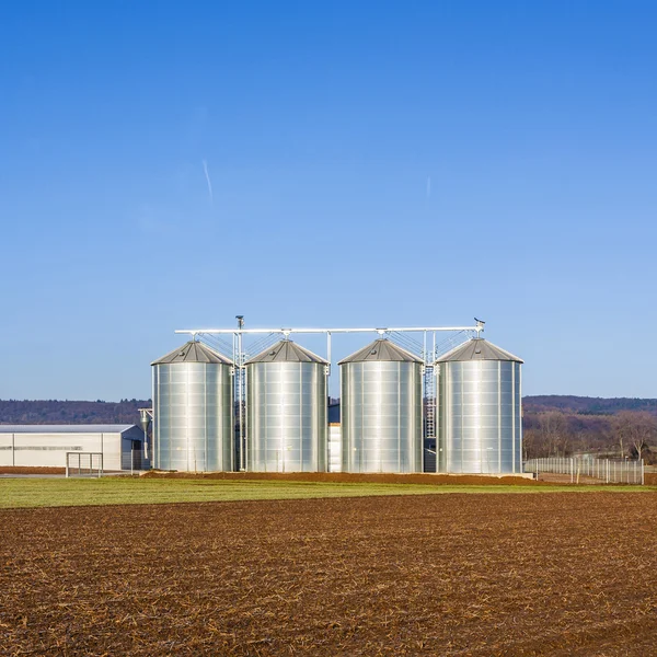 Landschaft mit Silo und schneeweißem Acker mit blauem Himmel — Stockfoto