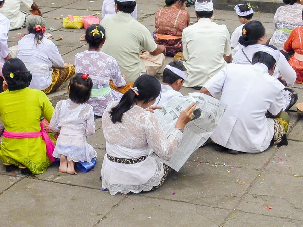 Femme lit un journal tout en participant à une cérémonie religieuse — Photo