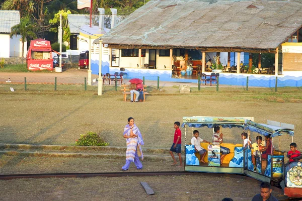 La gente disfruta montar el ferrocarril en una feria — Foto de Stock
