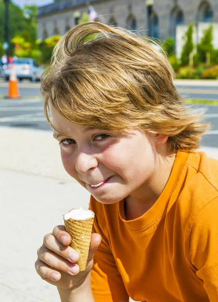 Um menino comendo um saboroso sorvete — Fotografia de Stock