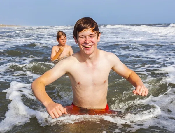 Meninos desfrutando as ondas no oceano selvagem — Fotografia de Stock