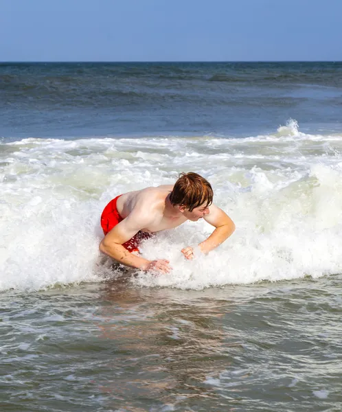 Boy has fun jumping in the waves Stock Photo