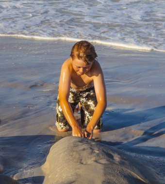 Çocuk kumsalda oynamaktan hoşlanıyor.
