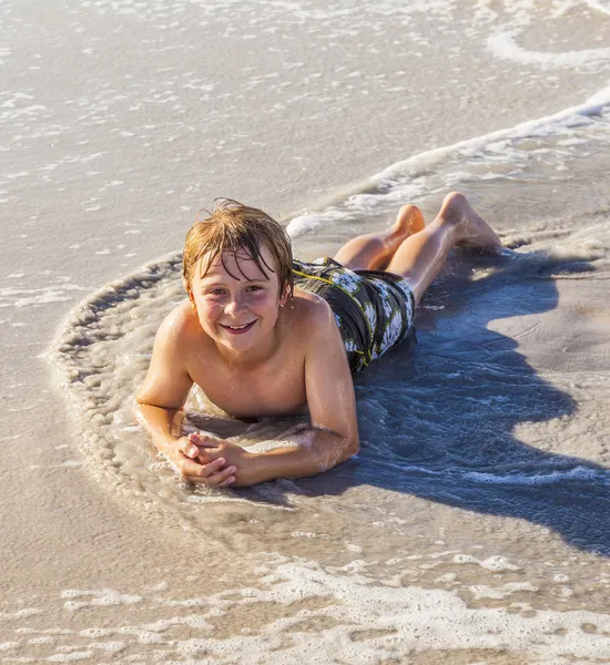 Chłopiec, leżąc na plaży i ciesząc się słońcem — Zdjęcie stockowe