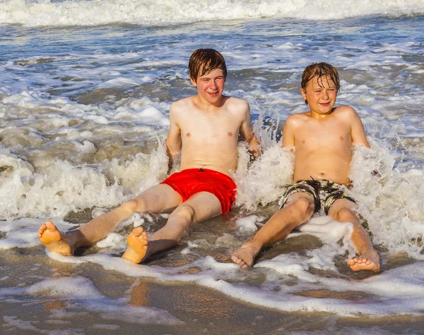 Αγόρια έχουν διασκέδαση στην υπέροχη θάλασσα σαφή — Φωτογραφία Αρχείου