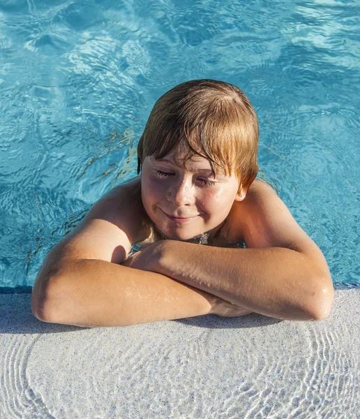 Barn resten på armbågen vid kanten av poolen — Stockfoto