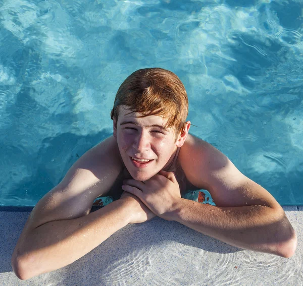 男孩有赖于他在泳池边的 ellbow — 图库照片