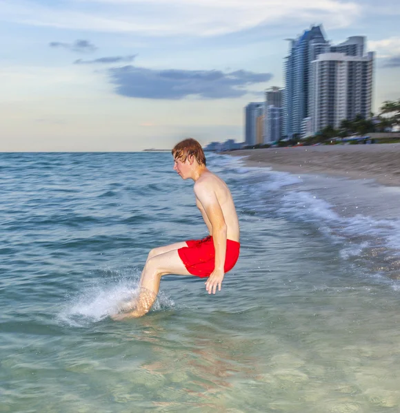 Garçon saute avec vitesse dans l'océan — Photo