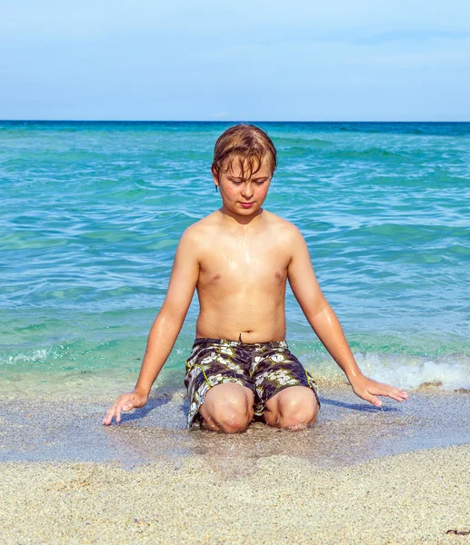 Pojken har det klara vattnet i havet — Stockfoto