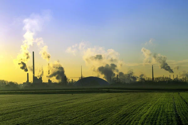 Paisagem da indústria no nascer do sol com chaminés para fumar — Fotografia de Stock