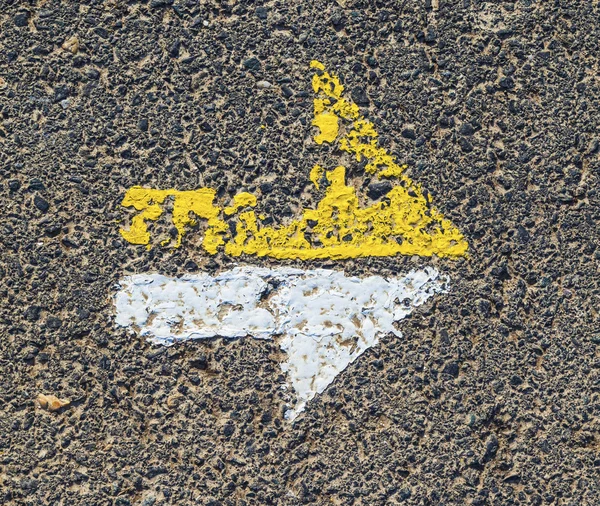Arrow in yellow and white on a paveway for orientation — Stock Photo, Image