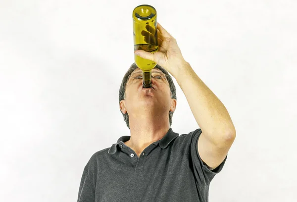 Man drinks alcohol out of a bottle — Stock Photo, Image