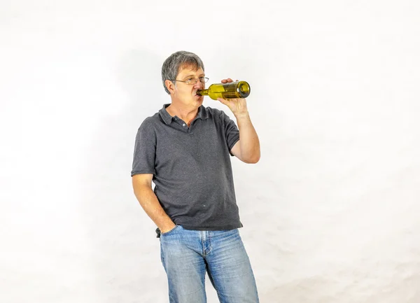 Homme boit de l'alcool dans une bouteille — Photo