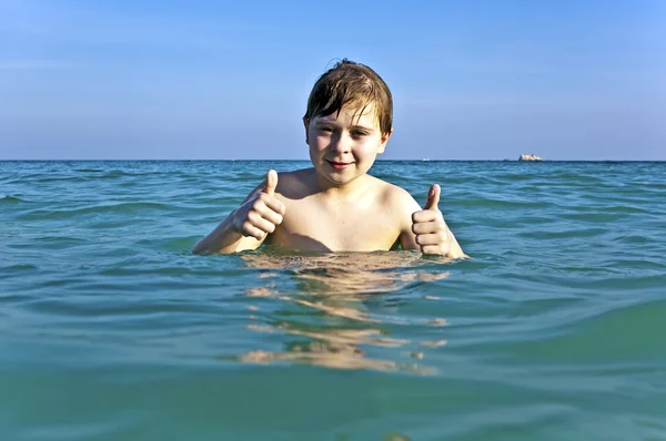 Vörös hajú fiú élvezi a tiszta meleg víz a gyön — Stock Fotó