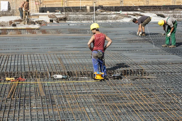 Arbeiter bauen Stahlstangen auf der Baustelle — Stockfoto