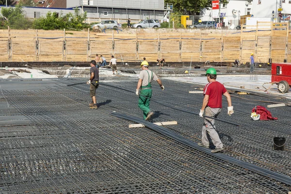 Pekerja melakukan konstruksi batang baja di lokasi bangunan — Stok Foto