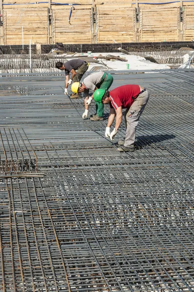 Arbeiter bauen Stahlstangen auf der Baustelle — Stockfoto