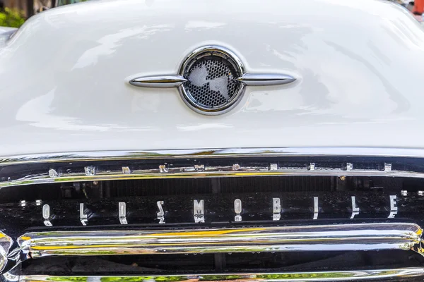 Classic Oldsmobile with chrome radiator grill parked in front o — Stock Photo, Image