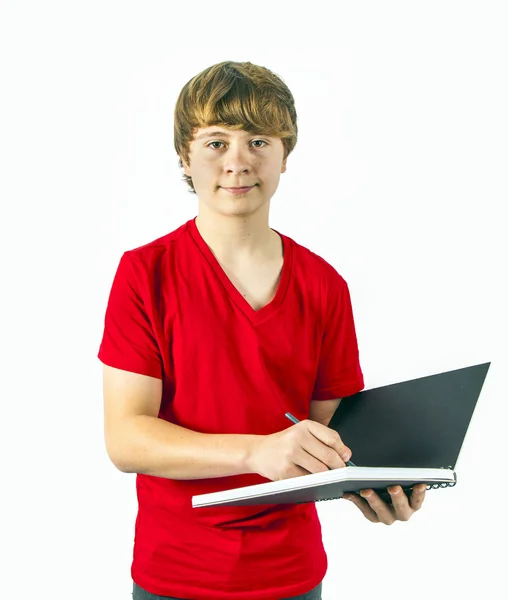 Chłopiec z czerwone koszule pisze w swojej książce — Zdjęcie stockowe