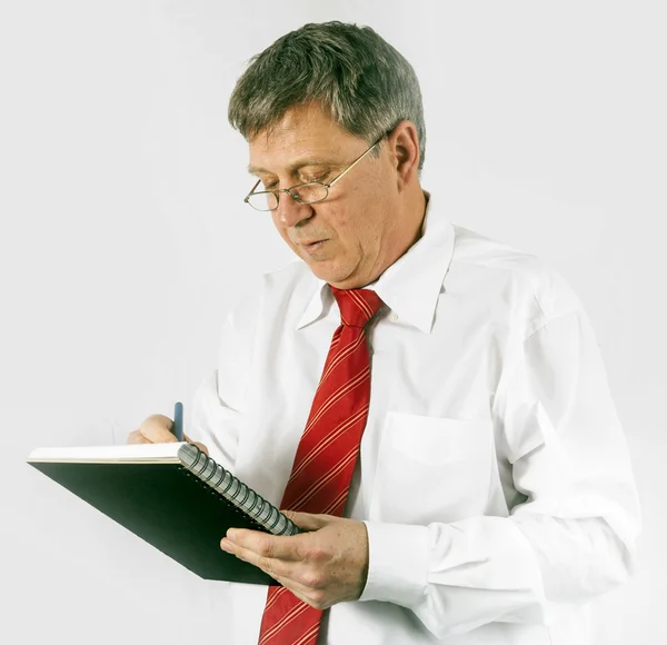 Ernstige zakenman schrijven in een boek — Stockfoto