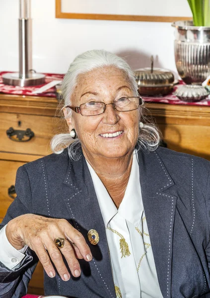 Attraktiv mormor sitter i hennes vardagsrum — Stockfoto