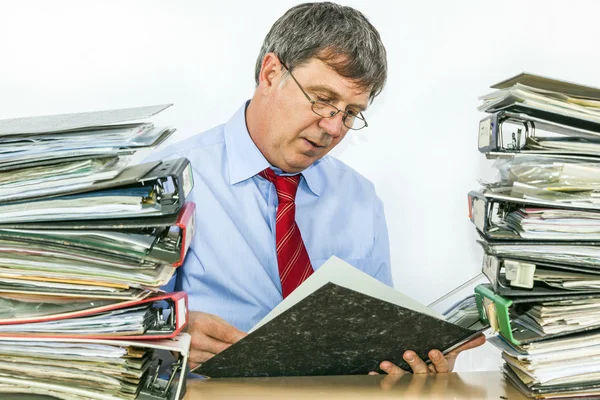 Hombre estudia carpeta con archivos en su escritorio en la oficina — Foto de Stock