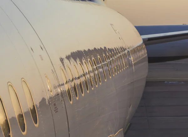 Avion avec reflet du coucher du soleil dans la fenêtre et le corps — Photo