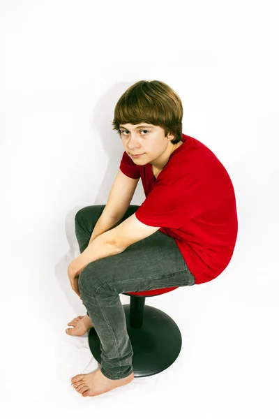 Adolescente sentado em uma cadeira — Fotografia de Stock