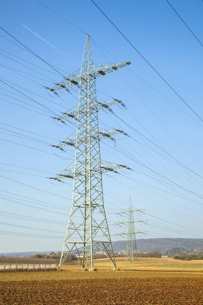 Paysage avec des mâts électriques au soleil — Photo