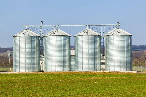 Silver silos in field Stock Picture