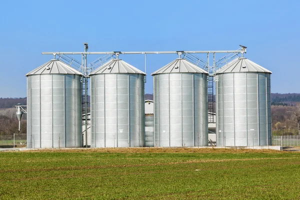 Zilveren silo's in veld — Stockfoto
