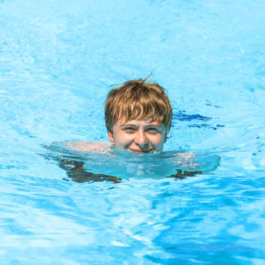 Havuzda yüzen çocuk.