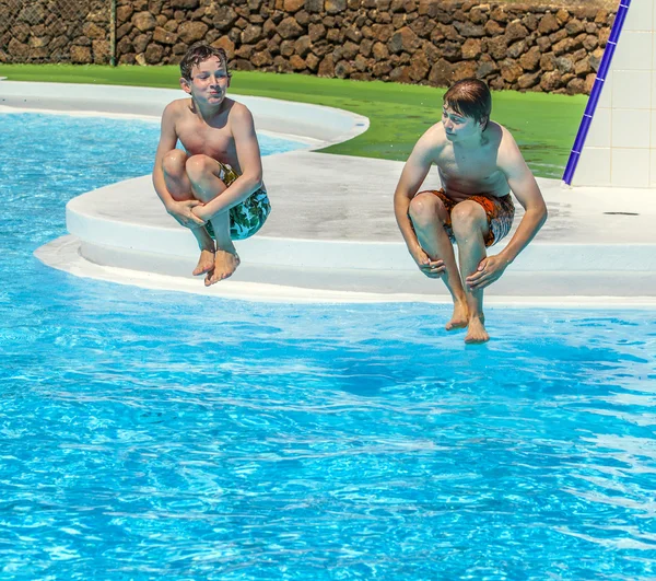 Two  friends jumping in the pool — Stock Photo, Image