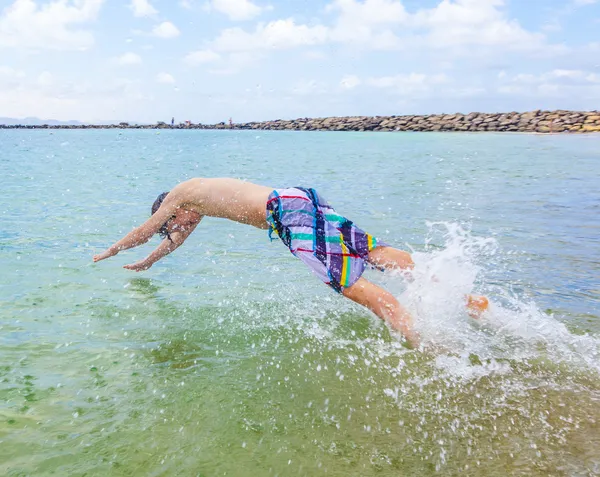 Glücklicher Junge genießt das Surfen in den Wellen — Stockfoto