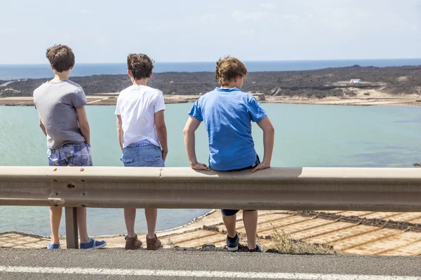 Três meninos inclinados no trilho guia — Fotografia de Stock