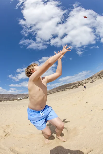 Ragazzo gode di giocare a palla in spiaggia — Foto Stock