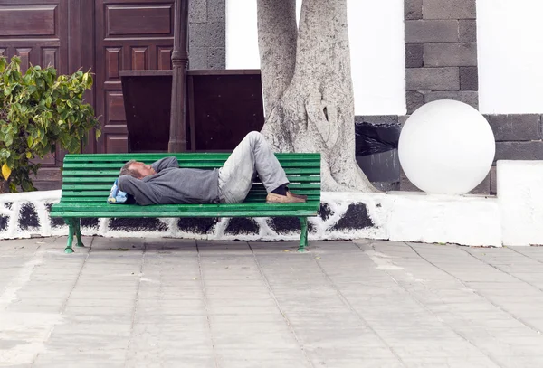 ARRECIFE, SPAGNA - 3 APRILE: l'uomo tiene una siesta su una panchina — Foto Stock
