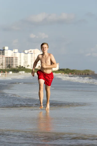 Teenager joggt gern am Strand entlang — Stockfoto