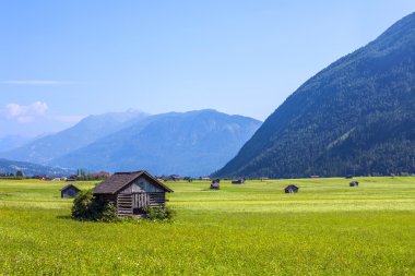 malzeme ve saman aust yeşil bir çayırda üzerinde depolamak için kulübeler