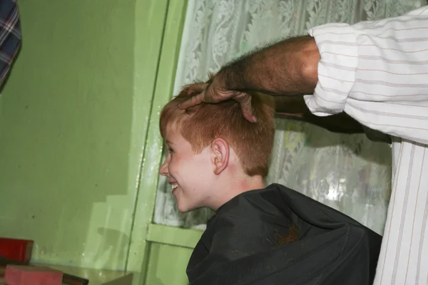 Caucasian boy with red hair at a local hairdresser — Stock Photo, Image