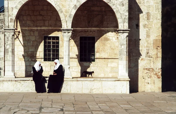 Mulheres árabes sentam-se na parede do templo — Fotografia de Stock