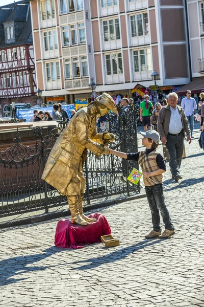 Pantomim i gyllene gamla klänning hälsar en pojke — Stockfoto