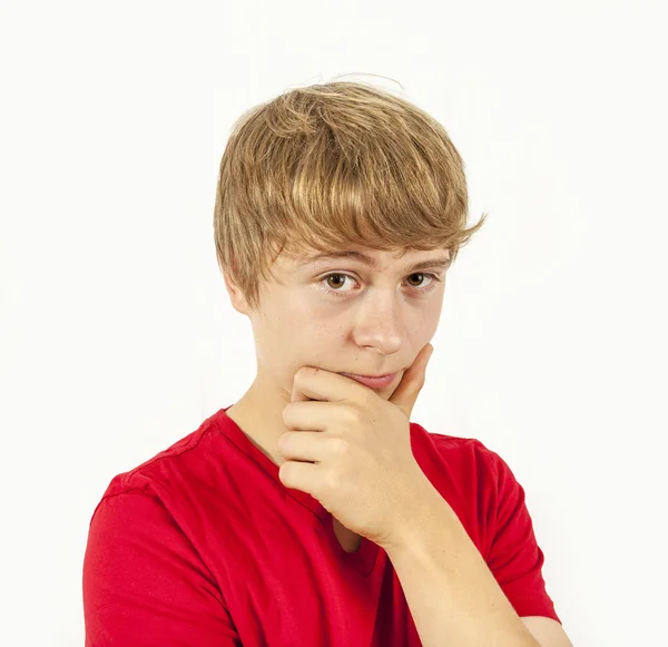 Handsome boy in red shirt keeps hand at chin — Stock Photo, Image