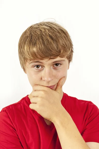 Handsome boy in red shirt keeps hand at chin — Stock Photo, Image